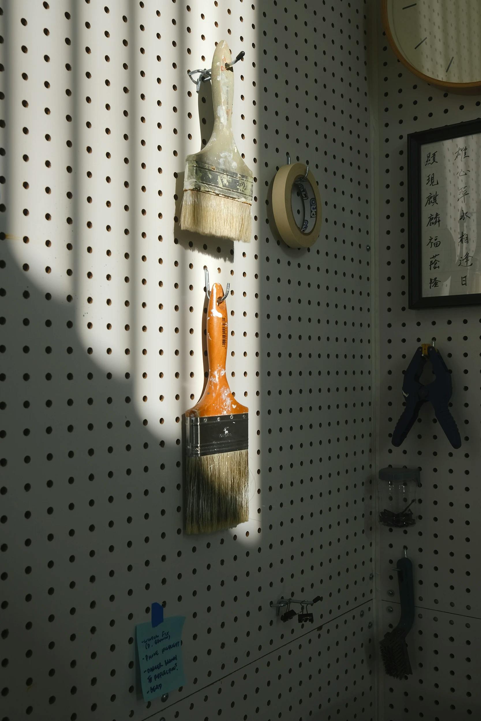 Paintbrushes hanging in Adrian Kay Wong's studio. 